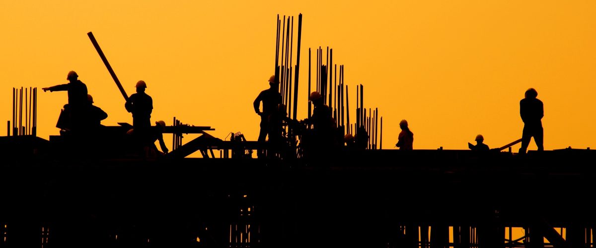 Construction workers at sunset.